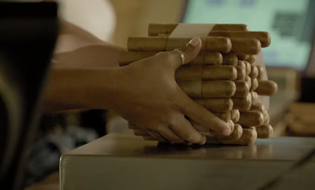 Hands holding cigars. Later, upon inspection, cigars are measured for diameter and weighed to ensure the sensitivity of the "torcedores" handiwork to exact specifications.