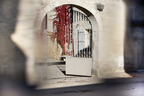 The main gate at Domaine Leflaive with a wall of red ivy on the building behind