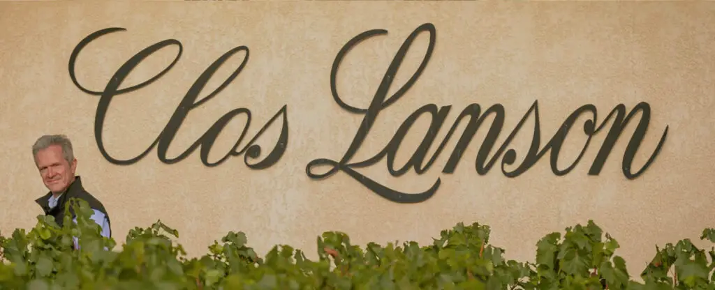 Winemaker walking past Clos Lanson wall sign